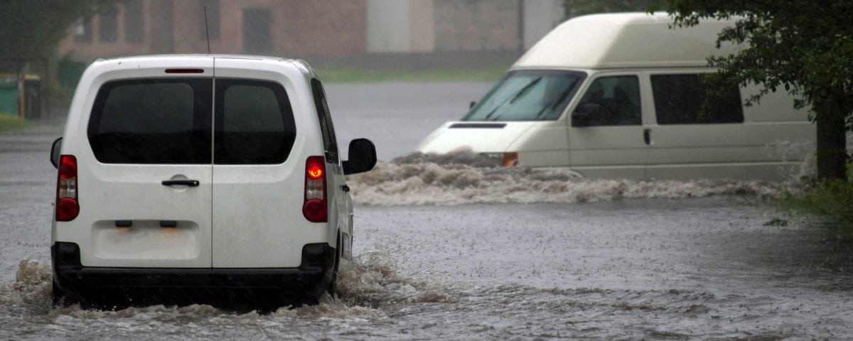 Two vans driving in flood waters