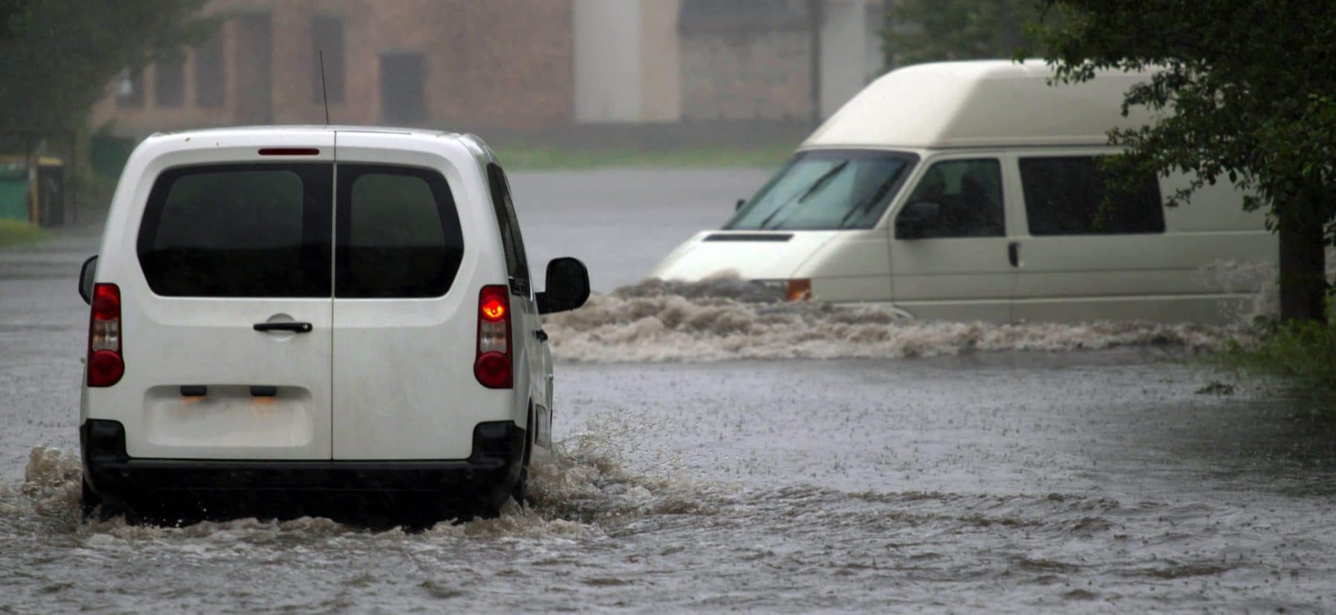 Two vans driving in flood waters