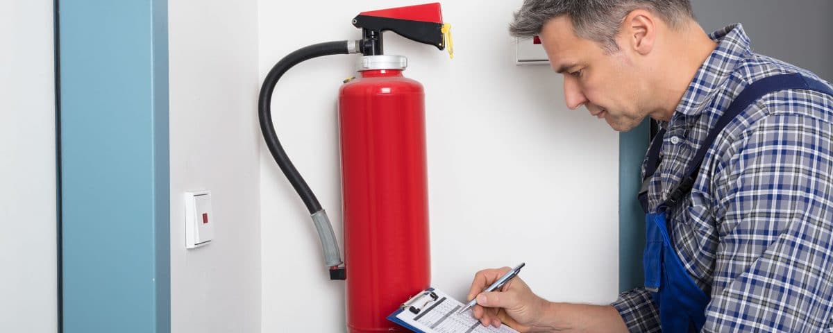 Man inspecting a fire extinguisher