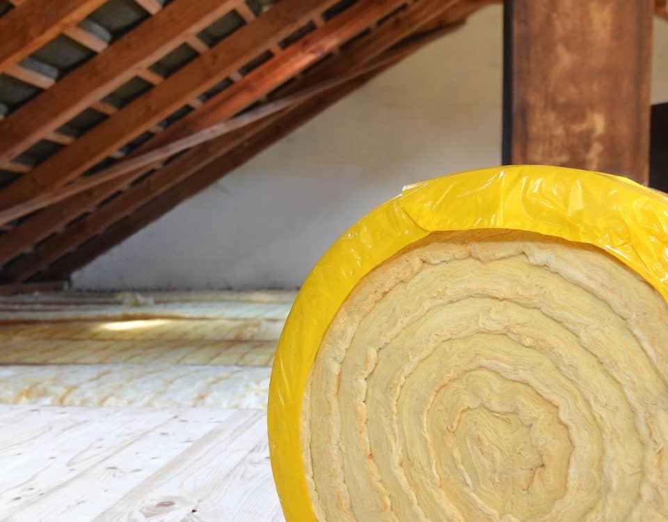 A roll of insulating glass wool on an attic floor