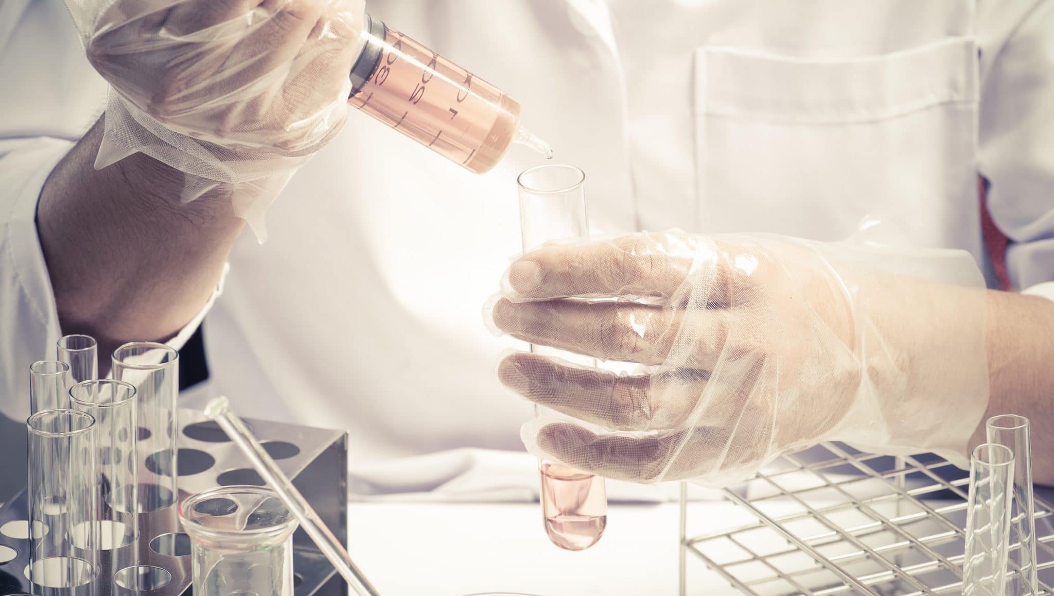 Conical flask in scientist hand with lab glassware background