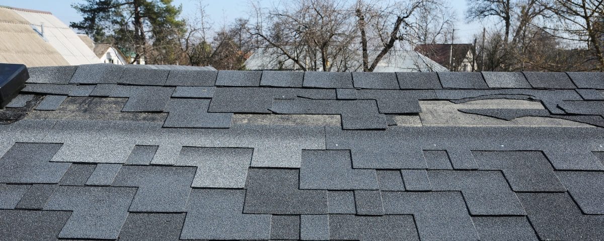 Residential asphalt shingle roof with damages