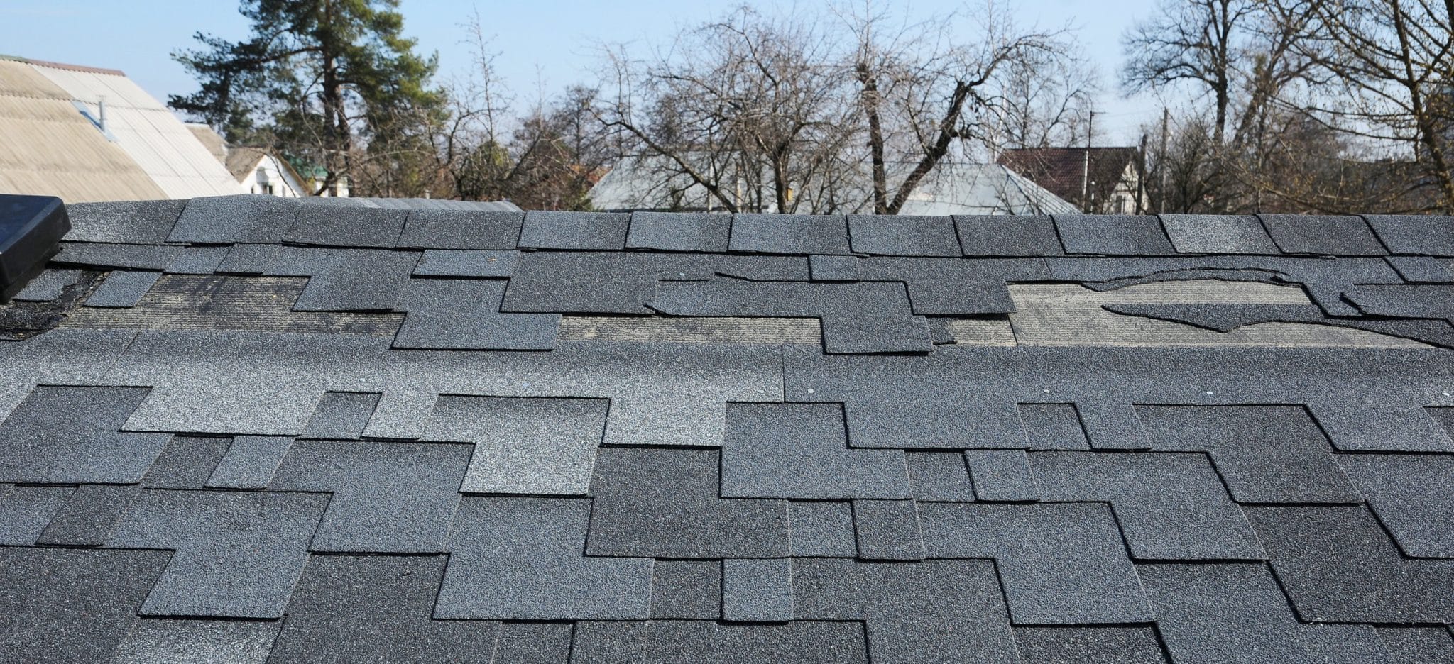 Residential asphalt shingle roof with damages