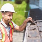 Worker inspecting the roofing of a home