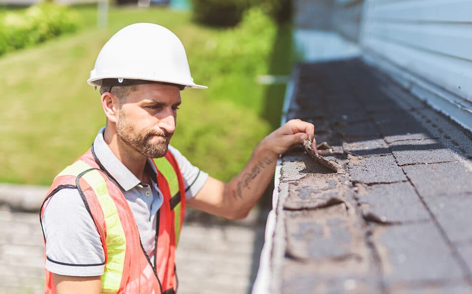 Worker inspecting the roofing of a home