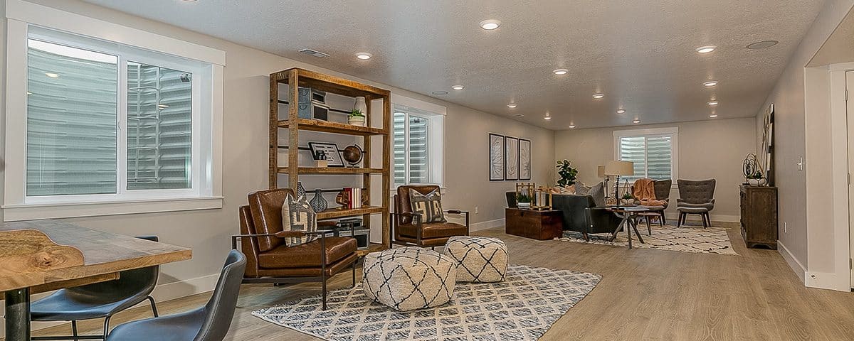 Basement of a home with table, shelves and seating