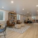 Basement of a home with table, shelves and seating